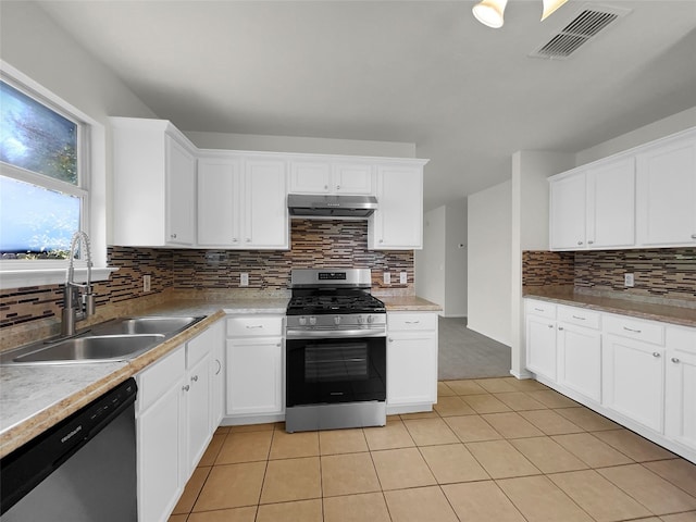 kitchen with light tile patterned flooring, white cabinetry, stainless steel appliances, decorative backsplash, and sink