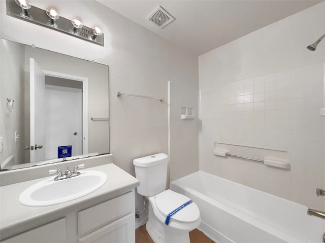 full bathroom featuring vanity, tiled shower / bath, and toilet