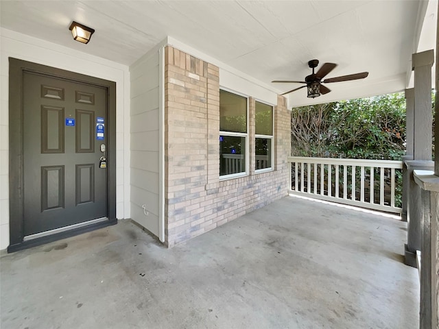 view of exterior entry featuring a porch and ceiling fan