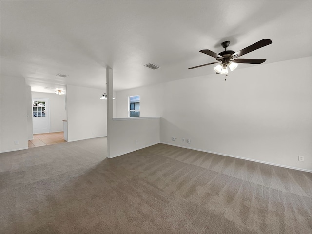 unfurnished living room featuring light carpet and ceiling fan