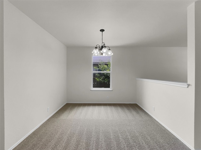 carpeted spare room featuring a notable chandelier