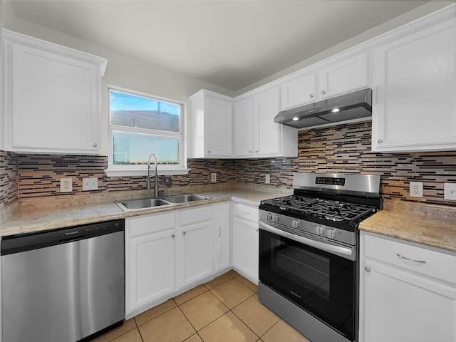 kitchen featuring white cabinets, decorative backsplash, sink, appliances with stainless steel finishes, and light tile patterned floors