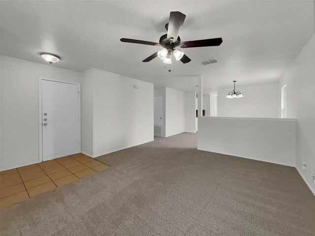 carpeted empty room with ceiling fan with notable chandelier