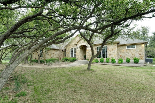 view of front of home with central air condition unit and a front yard