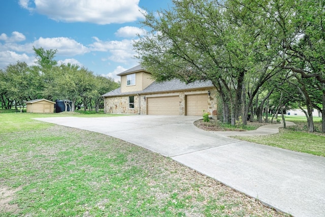 view of front of house with a garage, an outbuilding, and a front yard