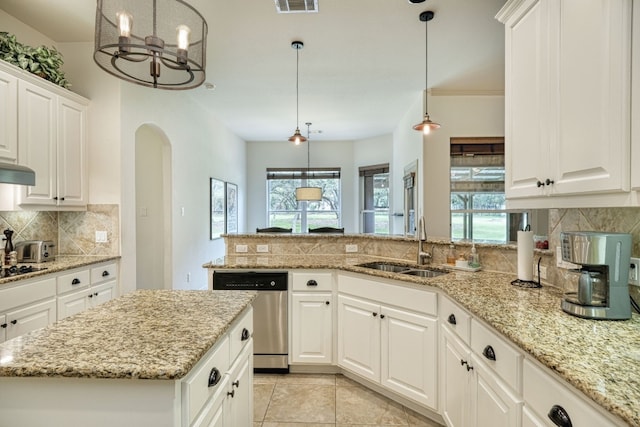 kitchen featuring stainless steel dishwasher, light stone countertops, tasteful backsplash, and a healthy amount of sunlight