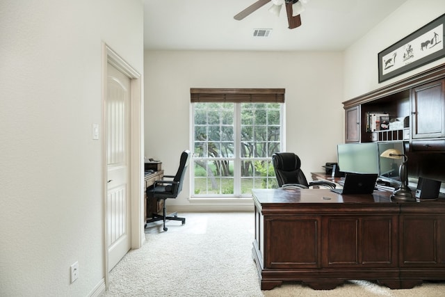 carpeted home office featuring ceiling fan