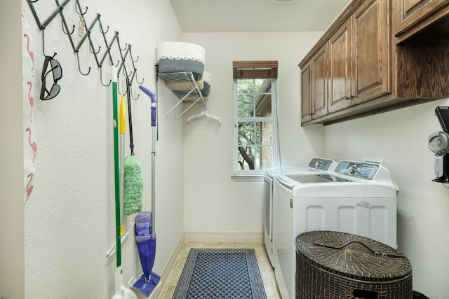 washroom with cabinets and washing machine and clothes dryer