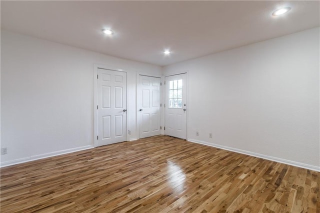 spare room featuring recessed lighting, wood finished floors, and baseboards