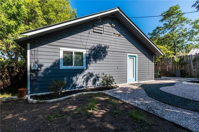 view of side of home with a patio area and fence