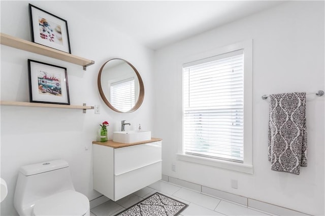 bathroom with toilet, tile patterned flooring, and vanity