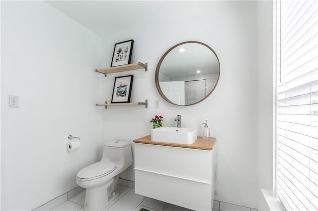 bathroom with a shower, vanity, toilet, and tile patterned floors