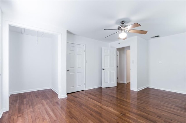 unfurnished bedroom with dark wood-type flooring, visible vents, baseboards, a closet, and attic access