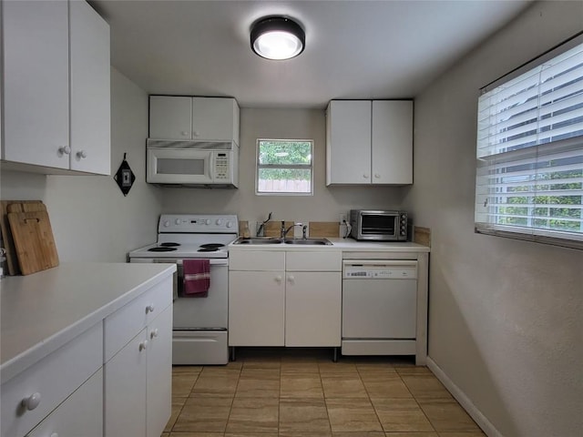 kitchen with light countertops, white appliances, and white cabinetry