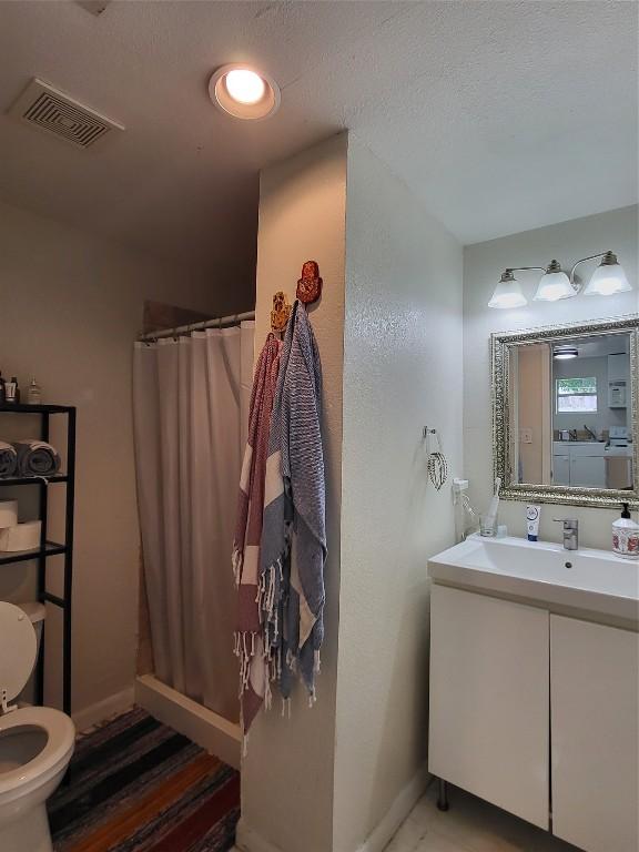 bathroom featuring baseboards, vanity, visible vents, and a shower with shower curtain