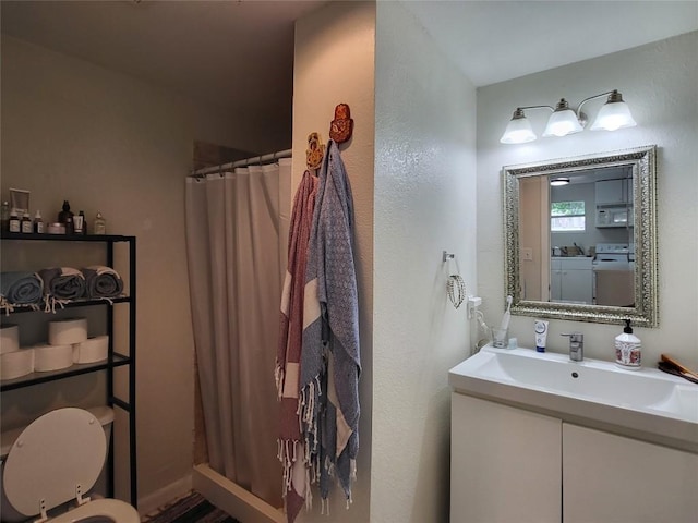 full bath with vanity, washing machine and clothes dryer, and a shower with shower curtain