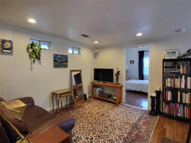 living room with baseboards, wood finished floors, visible vents, and recessed lighting