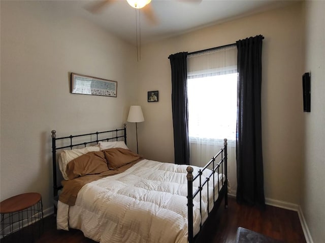 bedroom with dark wood-type flooring, ceiling fan, and baseboards