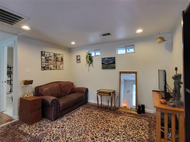 living area with recessed lighting, visible vents, and baseboards