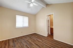 unfurnished room with ceiling fan, vaulted ceiling with beams, and dark wood-type flooring