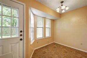 doorway featuring an inviting chandelier and tile patterned floors