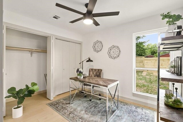 home office with ceiling fan, light hardwood / wood-style flooring, and a healthy amount of sunlight