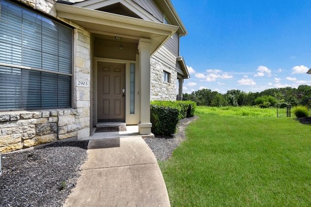 entrance to property with a lawn