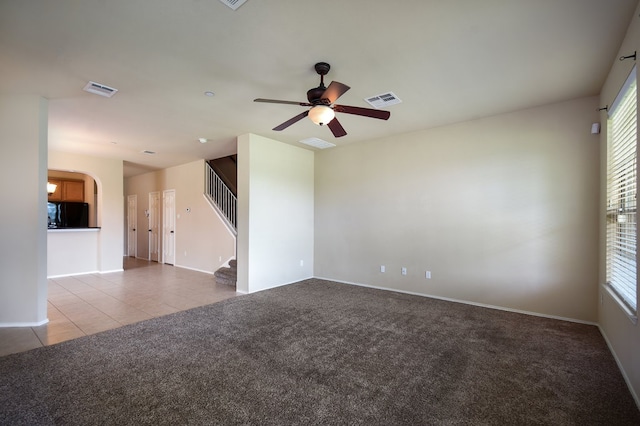 spare room with ceiling fan and light colored carpet