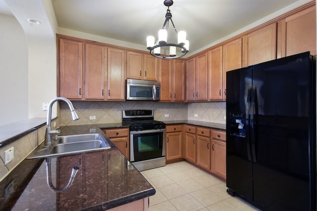 kitchen with sink, dark stone countertops, backsplash, and stainless steel appliances