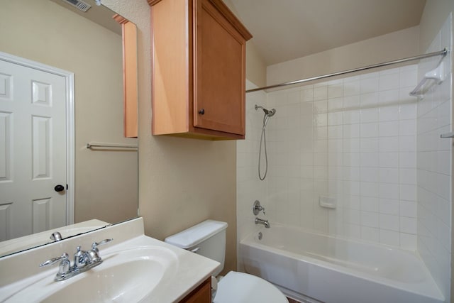 full bathroom featuring tiled shower / bath combo, toilet, and vanity