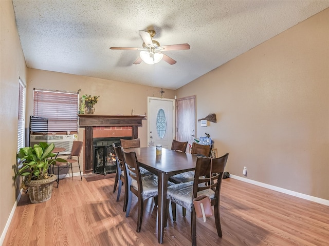 dining area with light wood-type flooring, ceiling fan, and a textured ceiling