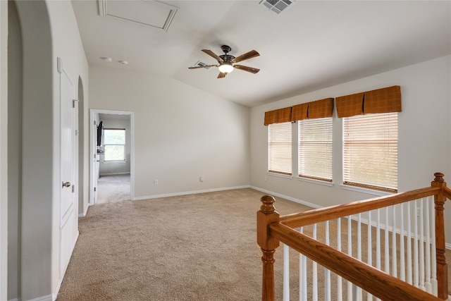 unfurnished room with vaulted ceiling, light colored carpet, and ceiling fan