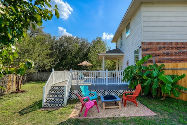 view of yard with a wooden deck and an outdoor fire pit