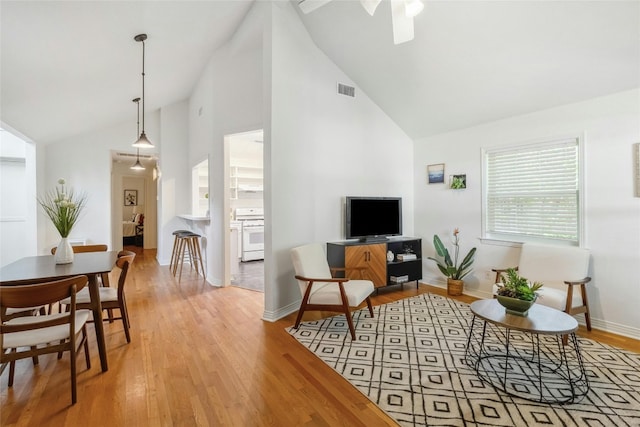 living room featuring light hardwood / wood-style floors and high vaulted ceiling