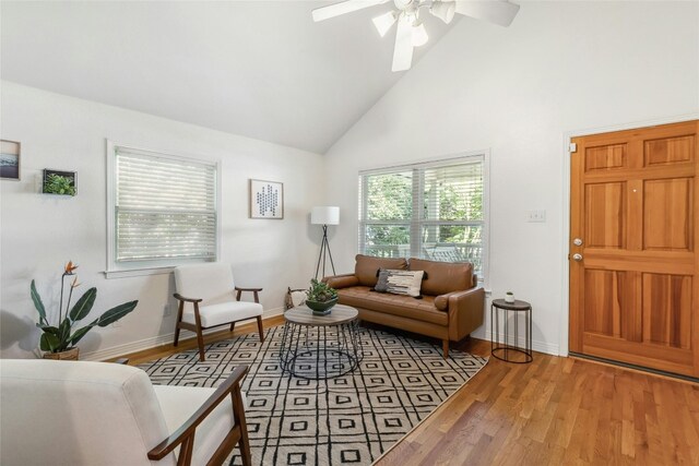 living room featuring high vaulted ceiling, light hardwood / wood-style flooring, and ceiling fan