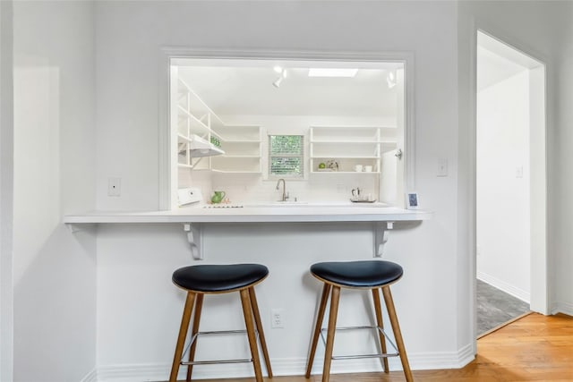 bar featuring sink and wood-type flooring