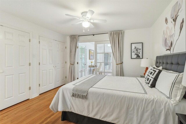 bedroom with multiple closets, light hardwood / wood-style floors, and ceiling fan