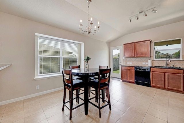 dining area with light tile patterned floors, a healthy amount of sunlight, vaulted ceiling, and sink