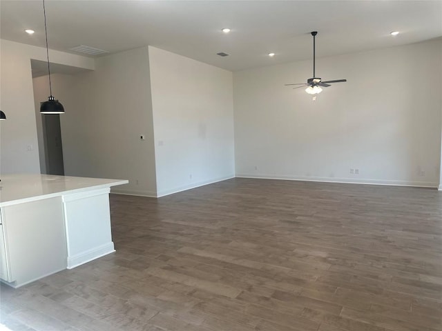 unfurnished living room featuring ceiling fan and dark hardwood / wood-style floors