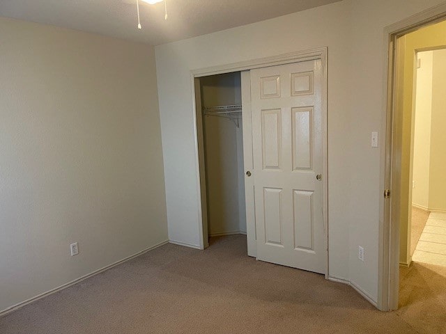 unfurnished bedroom with a closet and carpet floors