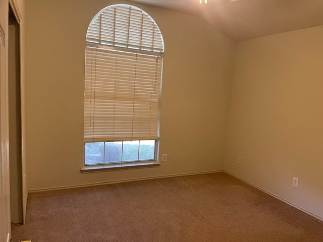 unfurnished room with carpet flooring and vaulted ceiling