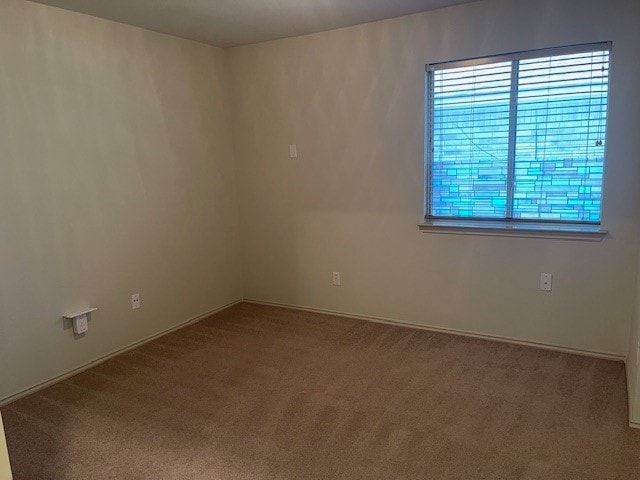 carpeted spare room featuring a healthy amount of sunlight