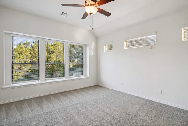 carpeted empty room with vaulted ceiling, ceiling fan, and a wealth of natural light