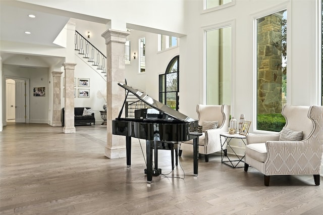 miscellaneous room with ornate columns, a high ceiling, and light hardwood / wood-style flooring