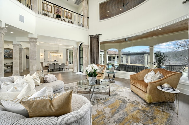 living room featuring wood-type flooring and ornate columns