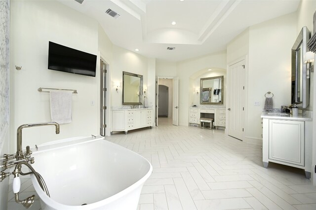 14132 Flat Top Ranch Rd, Austin, TX 78732 - bathroom with two vanities, a freestanding bath, recessed lighting, and a raised ceiling