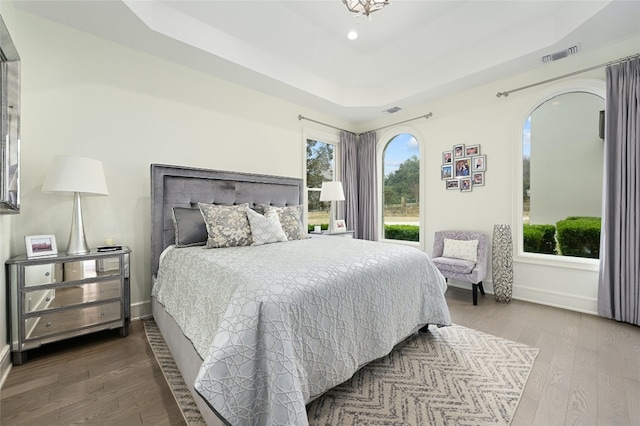 bedroom featuring hardwood / wood-style floors and a tray ceiling