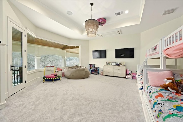 carpeted bedroom featuring a tray ceiling, a chandelier, and access to outside