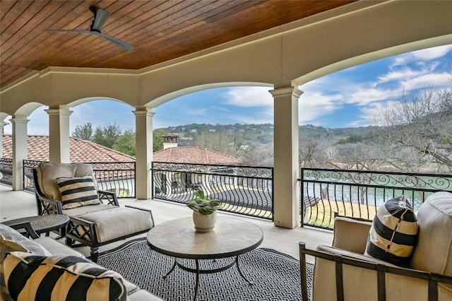 view of patio featuring ceiling fan, a balcony, and a water view