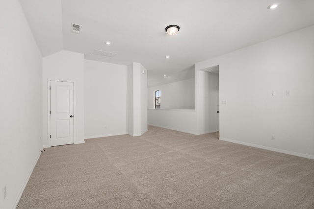 empty room with light carpet and vaulted ceiling